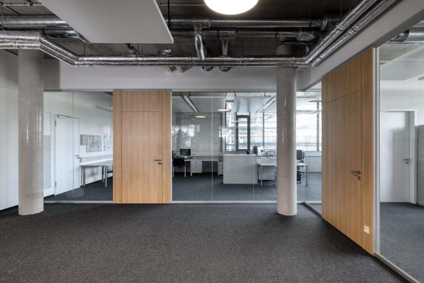 Erhardt + Leimer Elektroanlagen | Bürofläche mit Glaswänden und Holztüren